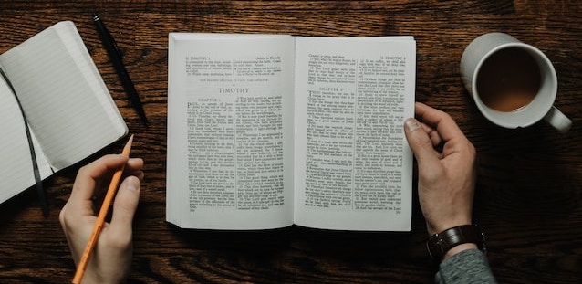 person reading study book and writing notes